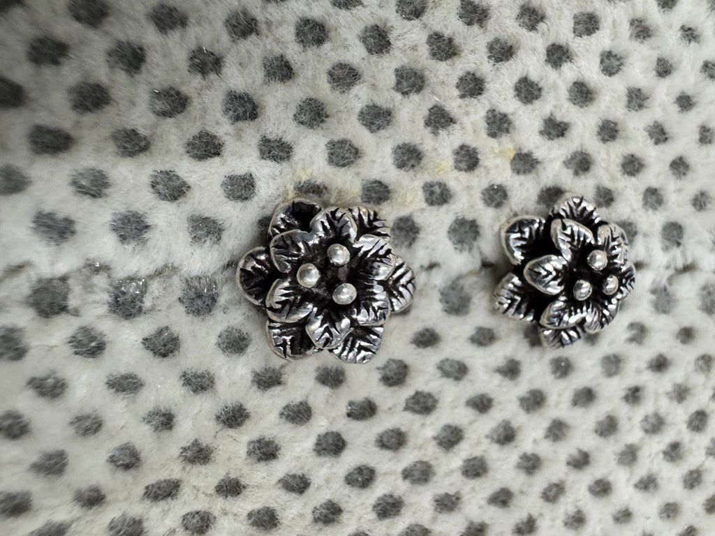 Close view of the layered petals and central granules on the oxidised sterling silver flower studs.