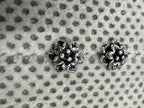 Close view of the layered petals and central granules on the oxidised sterling silver flower studs.