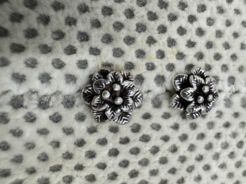 Close view of the layered petals and central granules on the oxidised sterling silver flower studs.