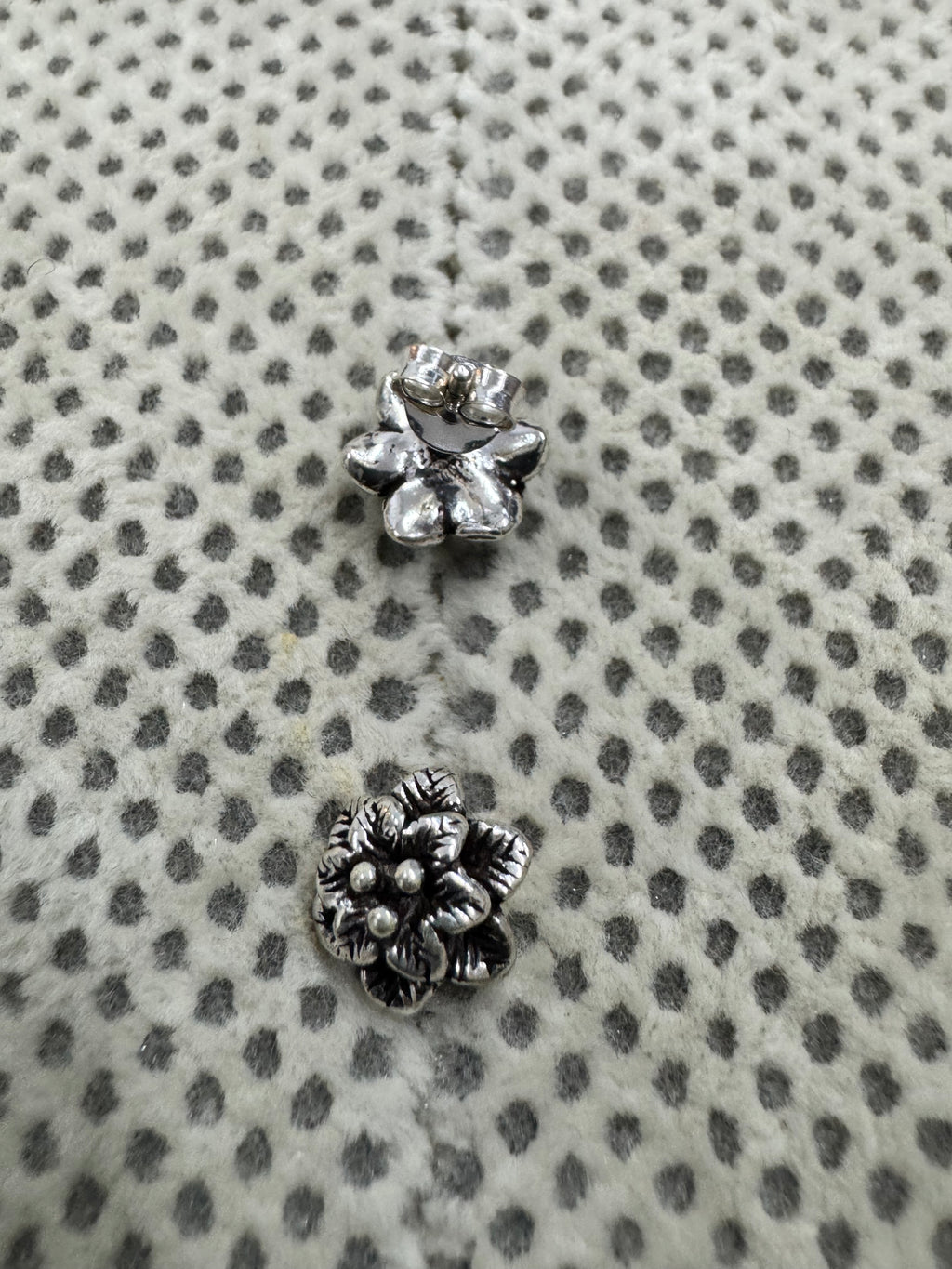 The pair of sterling silver flower studs, one turned to show the plain reverse and butterfly back.