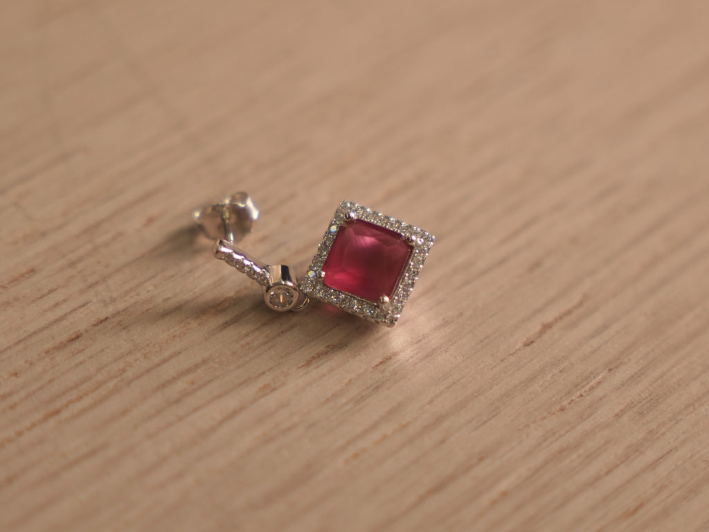 Angled view of the imitation ruby drop earrings, showing the bar studs and the swing of the square halos.
