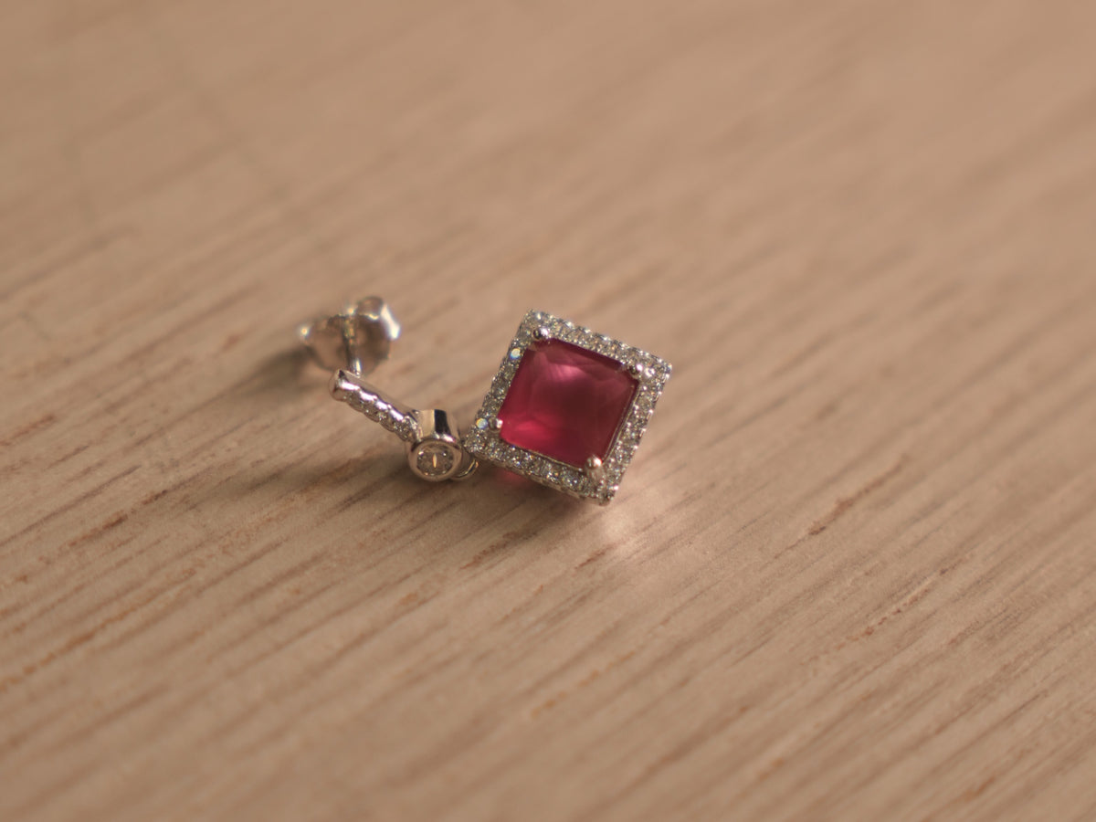 Angled view of the imitation ruby drop earrings, showing the bar studs and the swing of the square halos.