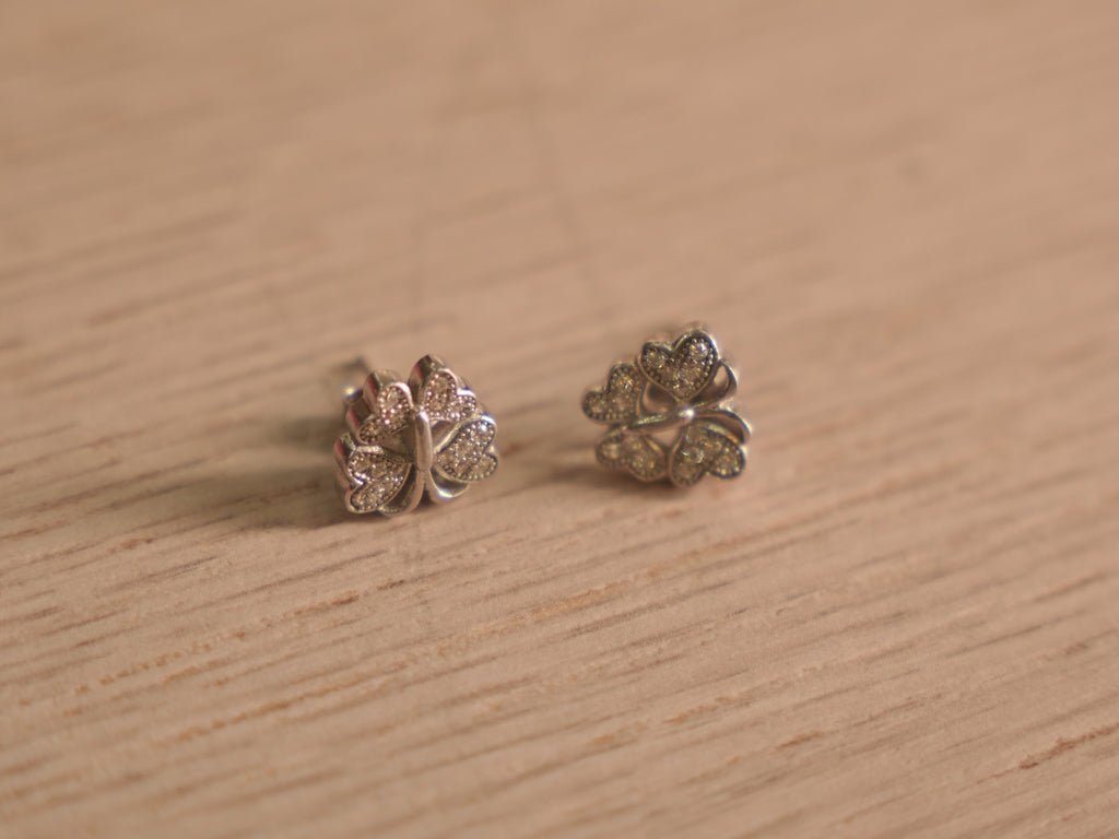Close view of the butterfly studs, showing the pave set wings and polished outlines.