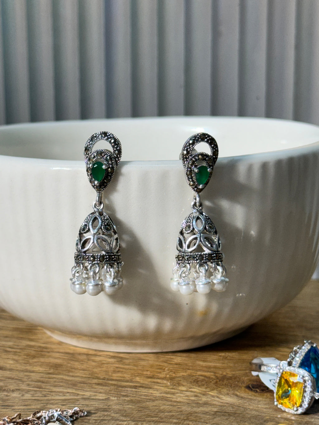 Close view of the jhumka dome, showing the faceted metal work and rows of small white beads.