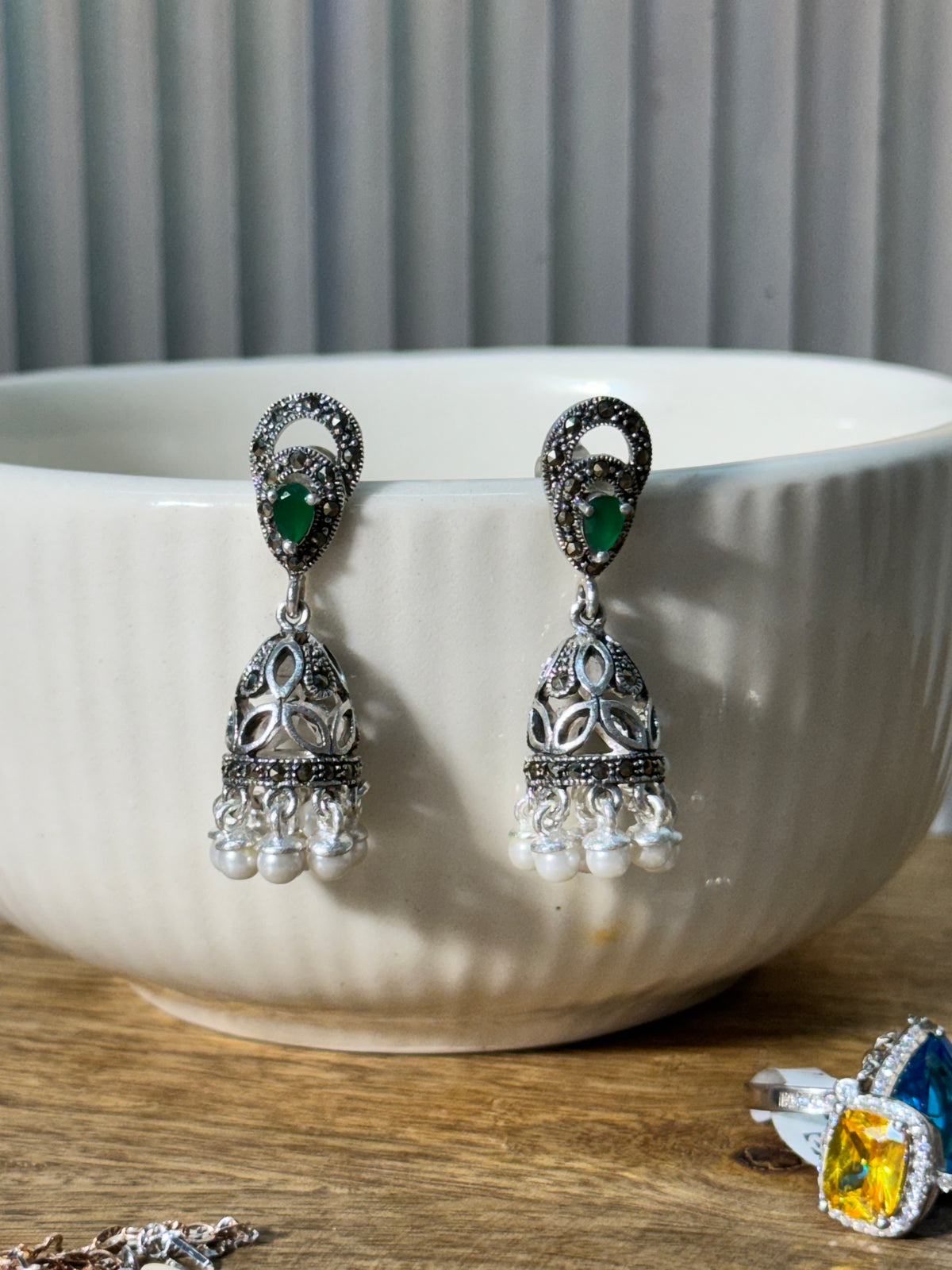 Close view of the jhumka dome, showing the faceted metal work and rows of small white beads.