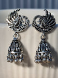 Pair of oxidised sterling silver crescent stud jhumkas with facing peacock detail.