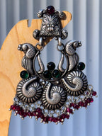 Pair of oxidised temple style statement earrings with peacocks, paisley scrolls and pink bead fringes.