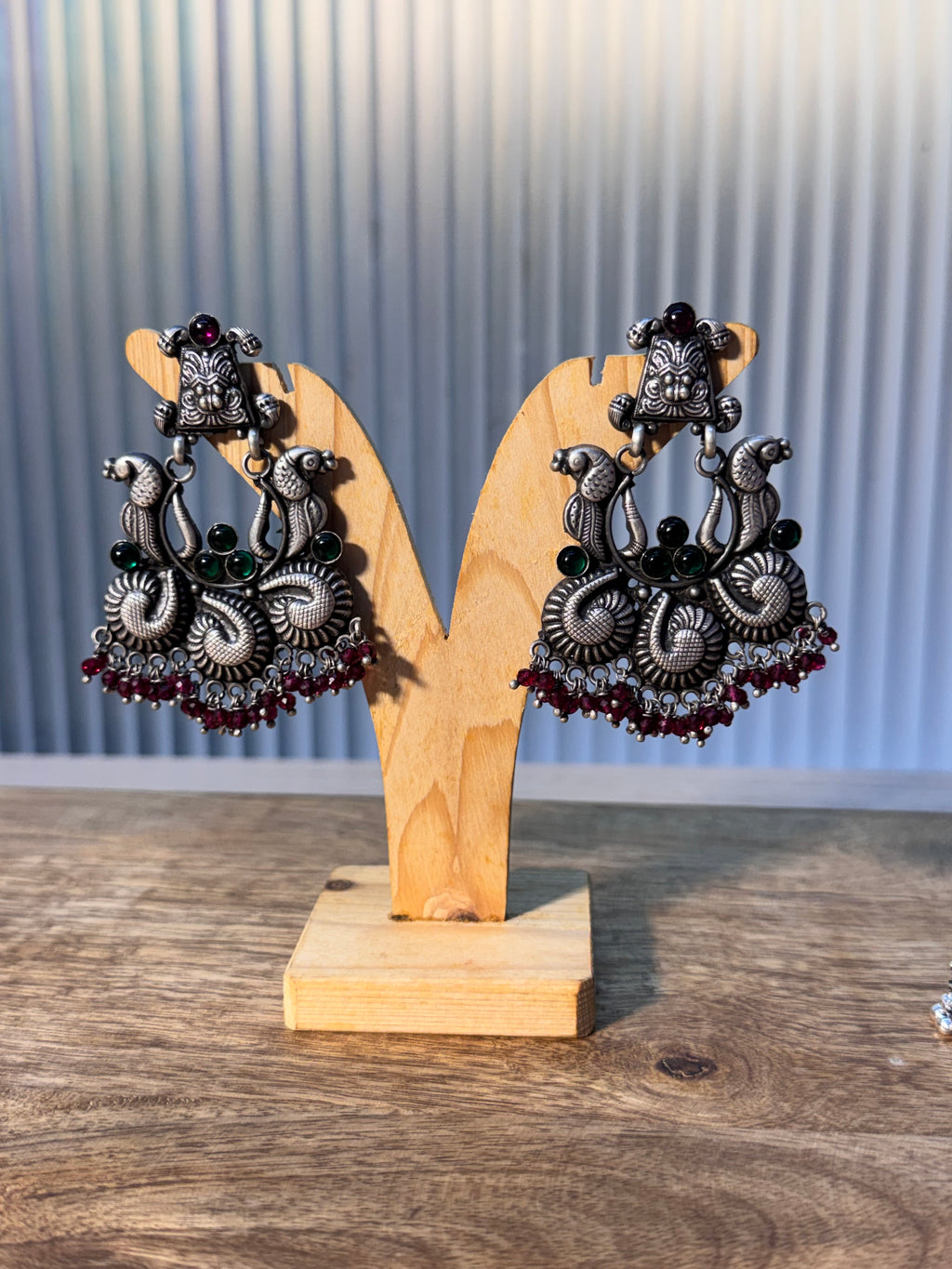 Single temple style earring upright, showing the three textured paisley scrolls and bead clusters.