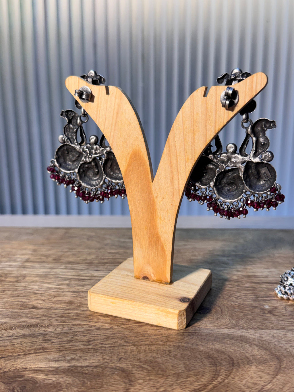 Close view of the pink faceted glass bead clusters along the lower edge of the earring.