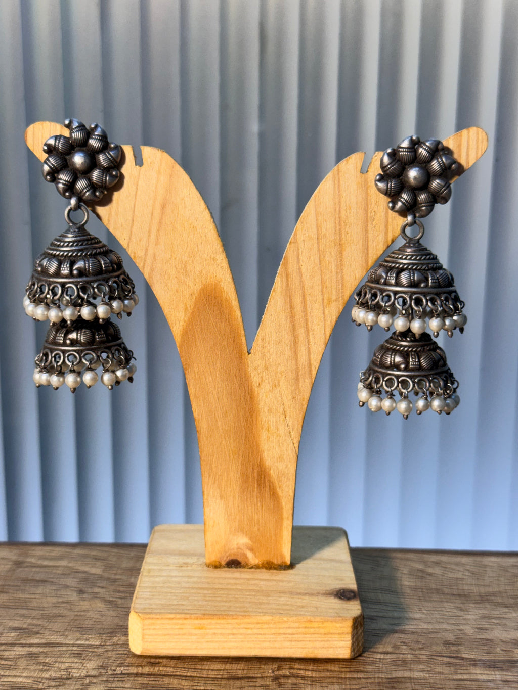 Pair of oxidised sterling silver tiered jhumkas edged with rows of small pearl drops.