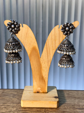 Pair of oxidised sterling silver tiered jhumkas edged with rows of small pearl drops.