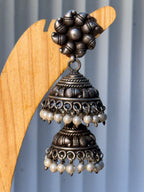 Close view of the tiered jhumka dome, showing the flower stud and staggered pearl rows.