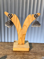 Pair of oxidised sterling silver jhumkas with triangular stepped domes and pearl drop fringes.