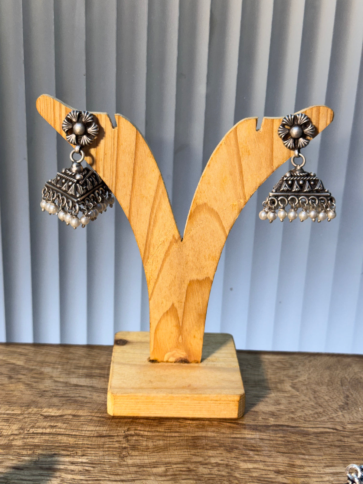 Pair of oxidised sterling silver jhumkas with triangular stepped domes and pearl drop fringes.