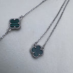 The green clover necklace beside the matching bracelet.