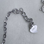 The extender chain and heart tag of the green clover necklace.