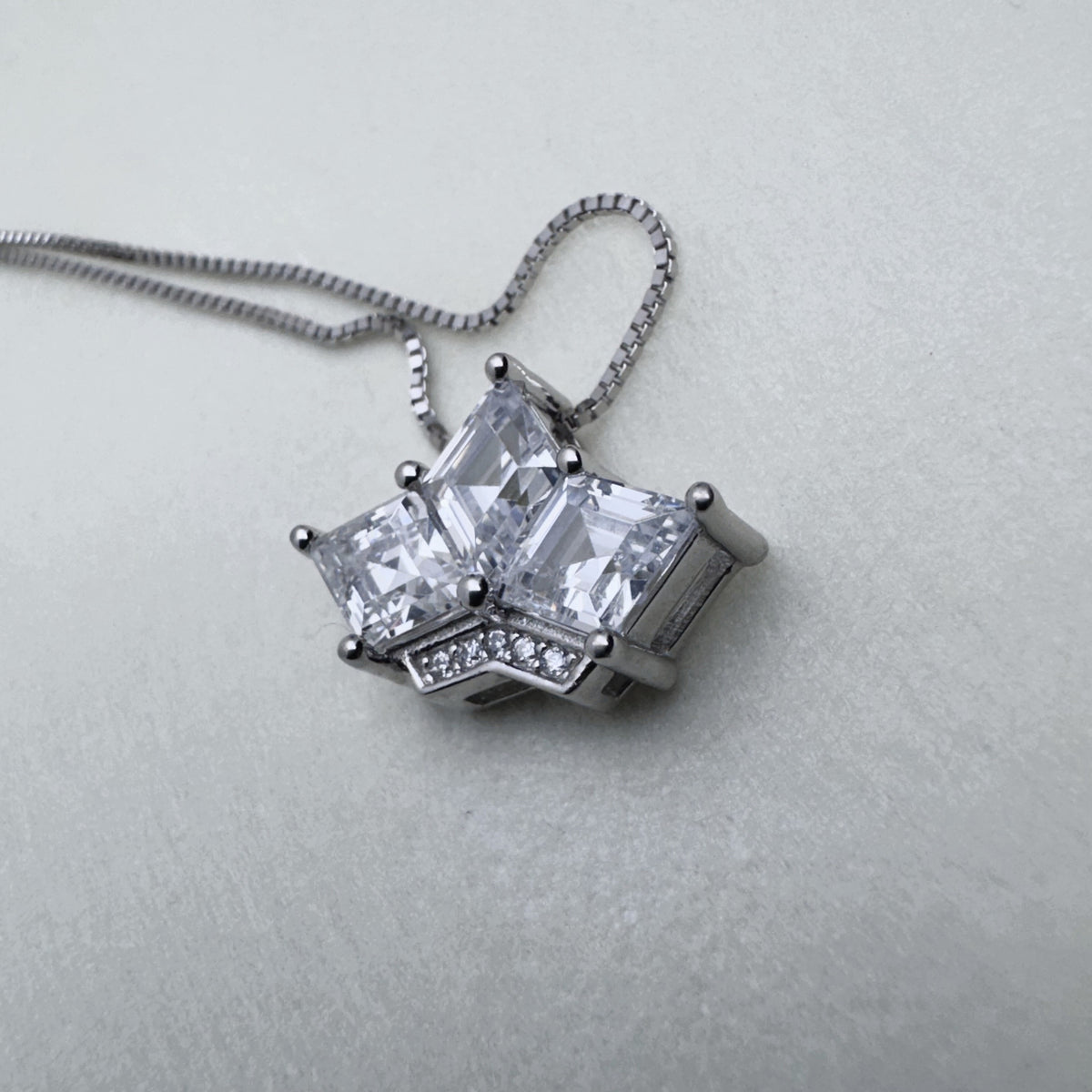Sterling silver crown pendant necklace with three princess-cut American Diamonds, on a box chain.