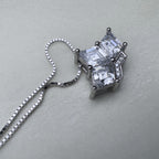 Close view of the three prong set princess-cut stones and the pave set band of the crown pendant.