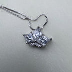 The crown pendant on its box chain, seen from above.