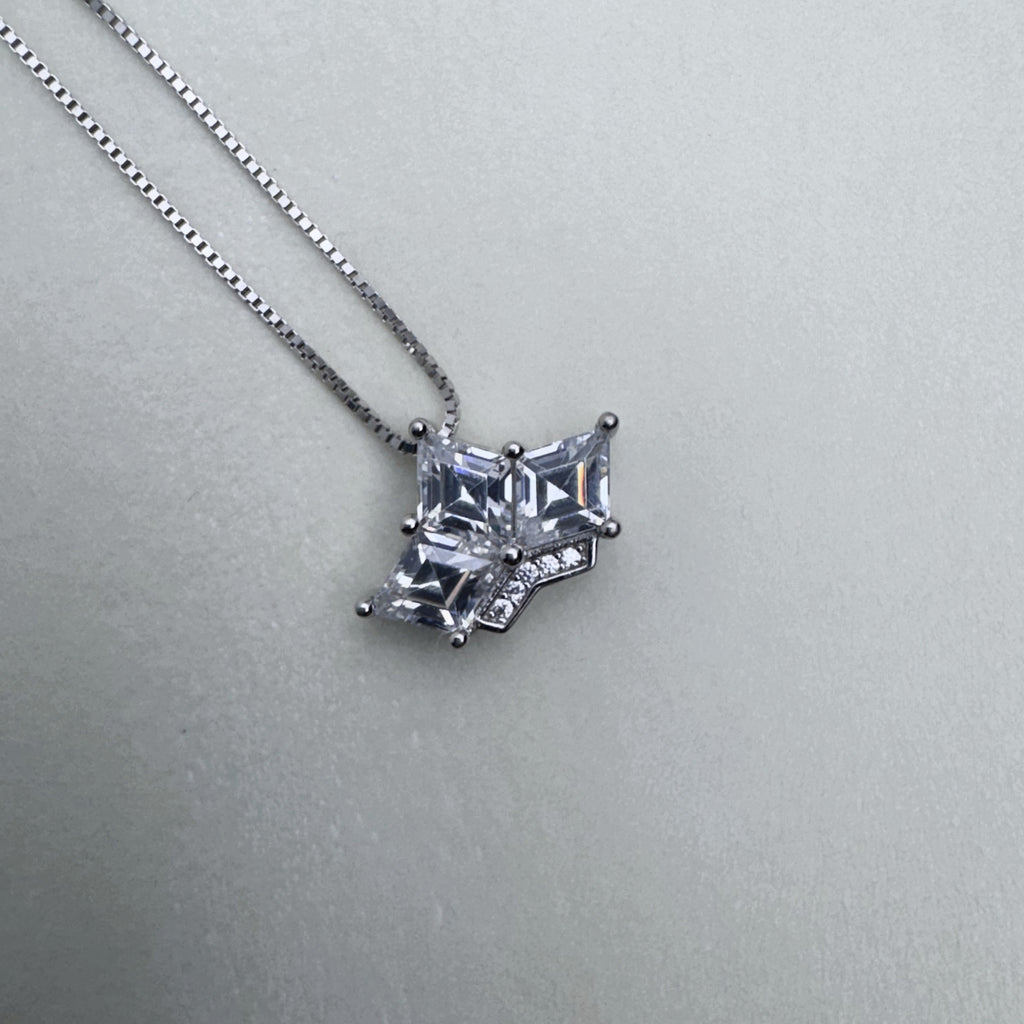 The crown pendant hanging from the box chain.