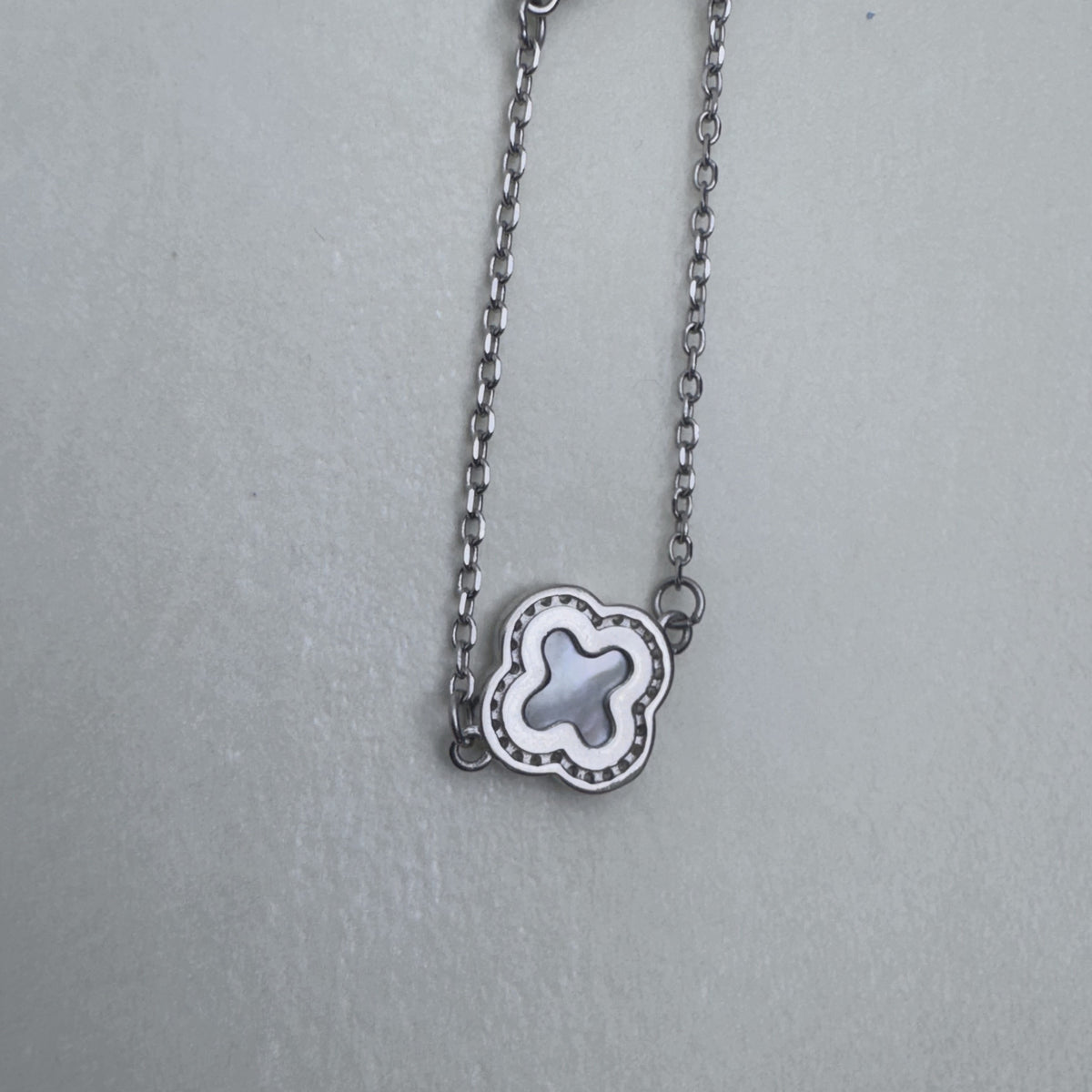A single mother of pearl clover station on the silver cable chain.