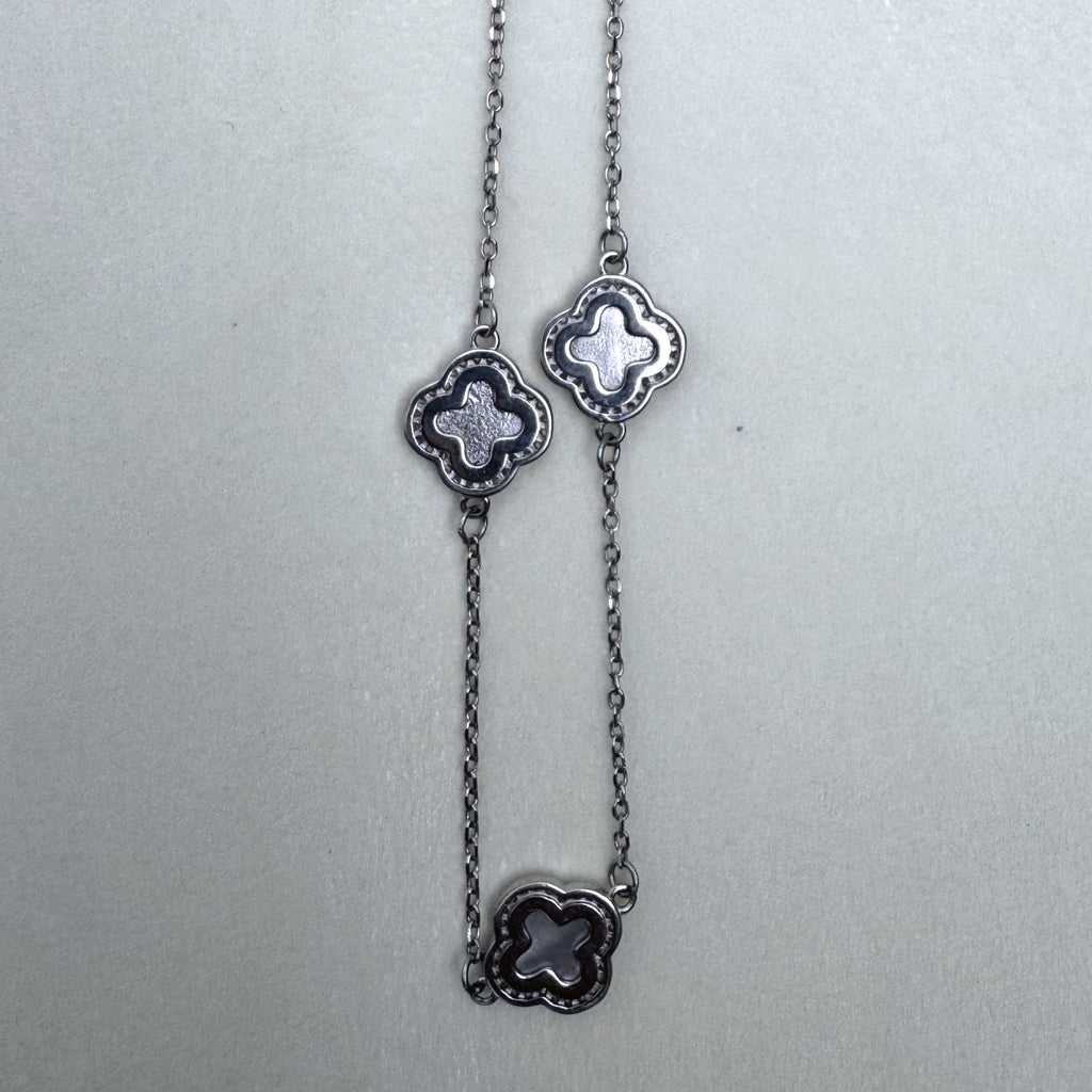 Three clover stations along the cable chain of the necklace.