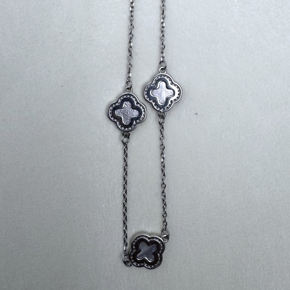 Three clover stations along the cable chain of the necklace.