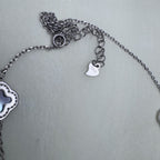 The lobster clasp, extender chain and tag of the silver station necklace.
