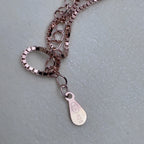 The extender chain and 925 tag of the rose-tone box chain.