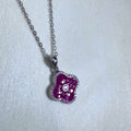 Sterling silver clover pendant necklace filled with red glass stones, hanging from a cable chain.