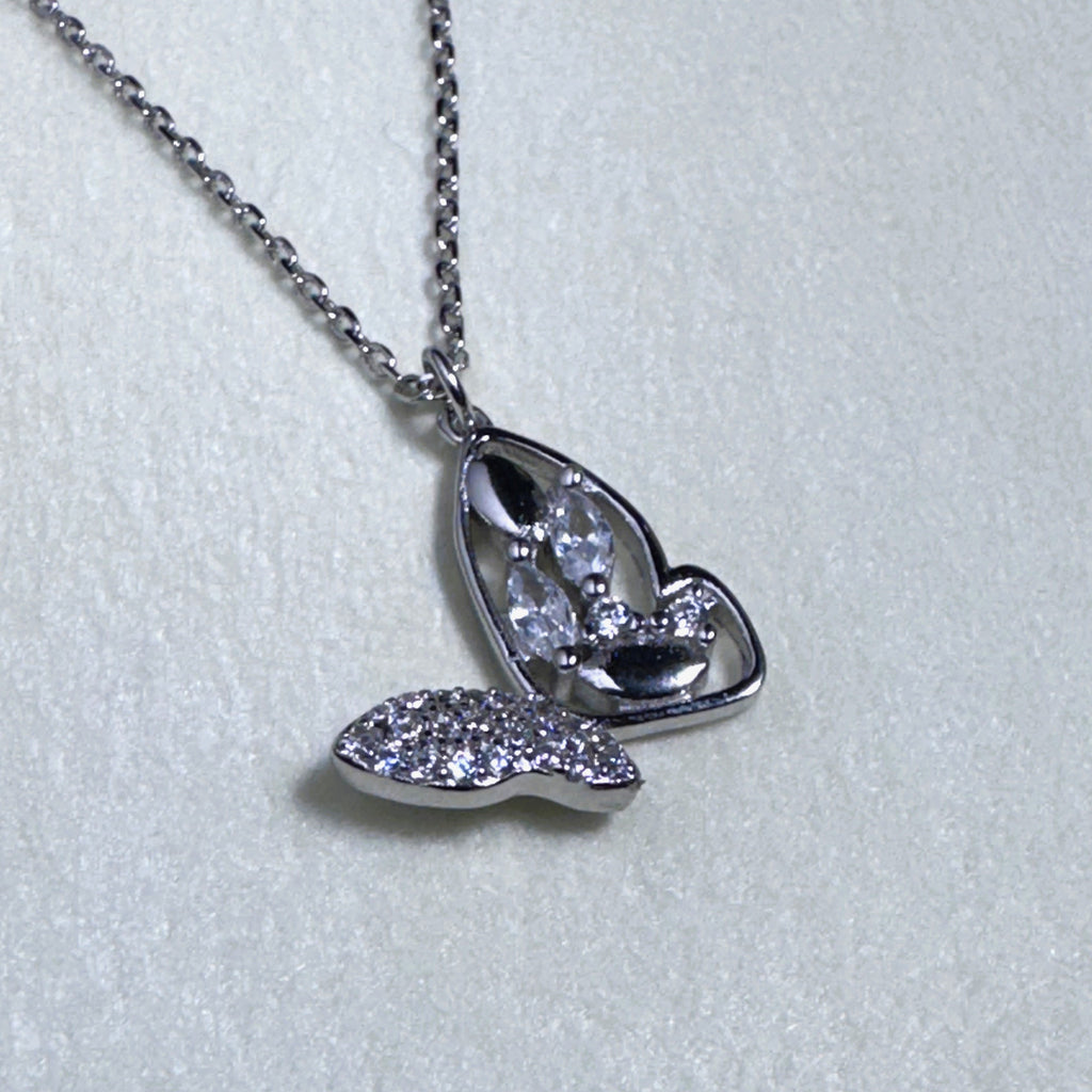 Sterling silver butterfly pendant necklace with one pave set wing and one open marquise wing, on a cable chain.