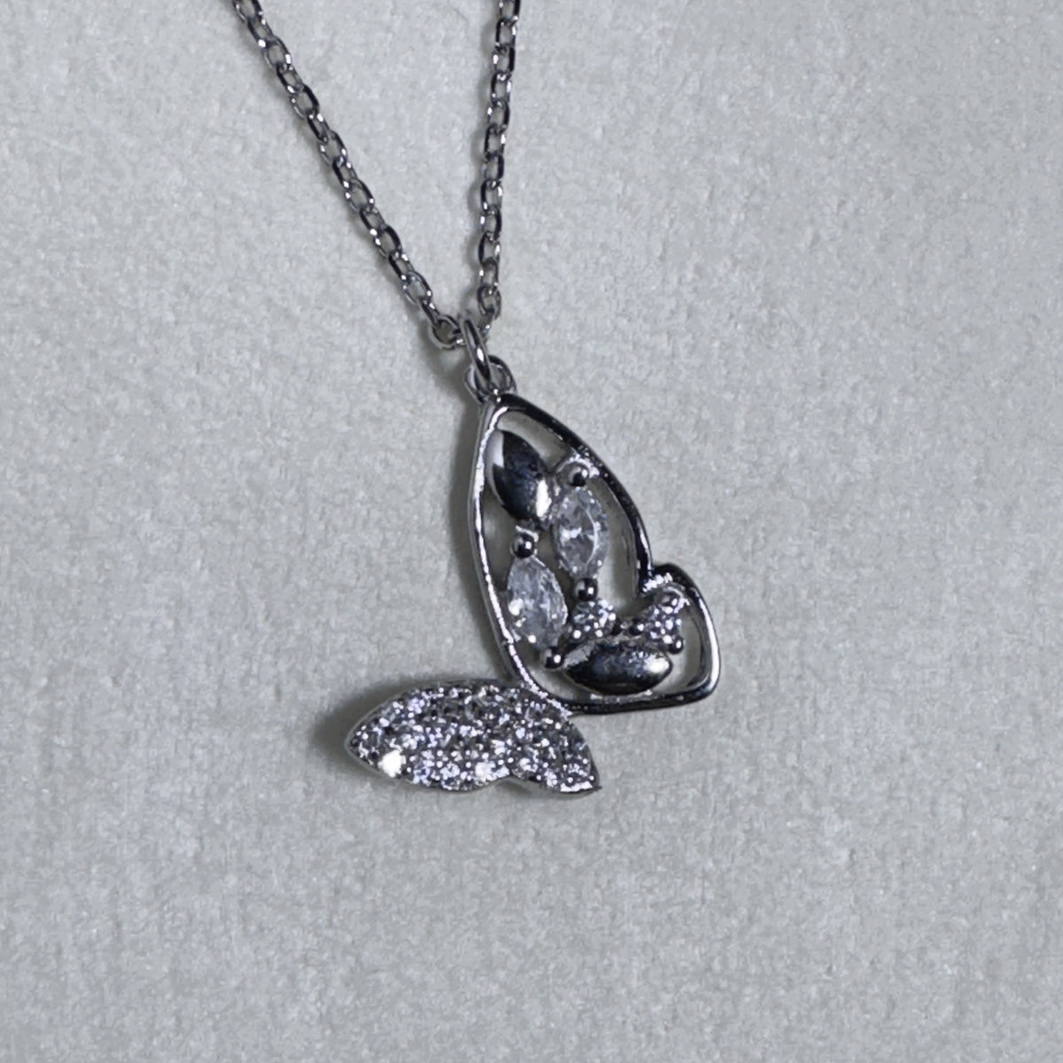 Close view of the open wing with its three marquise stones and the pave set wing beside it.