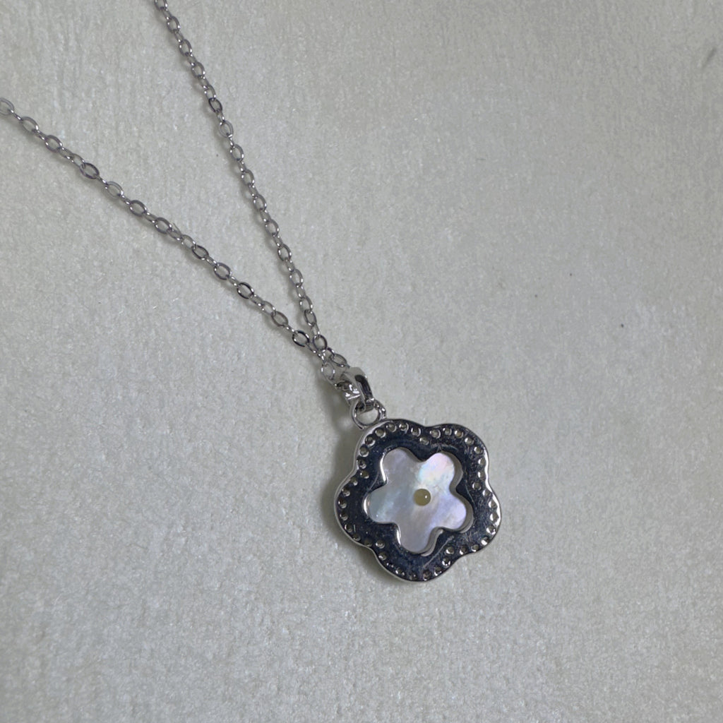 The flower pendant seen from the side on the cable chain.