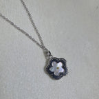 The flower pendant seen from the side on the cable chain.