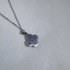The plain polished back of the flower pendant.