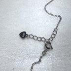 The spring ring clasp, extender chain and heart tag of the necklace.