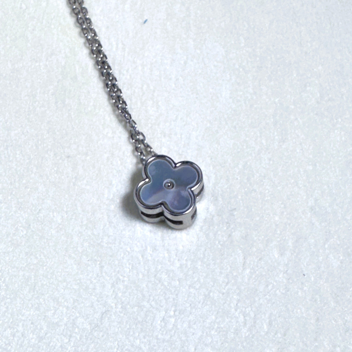 Sterling silver necklace with a small grey mother of pearl clover on a fine rolo chain.