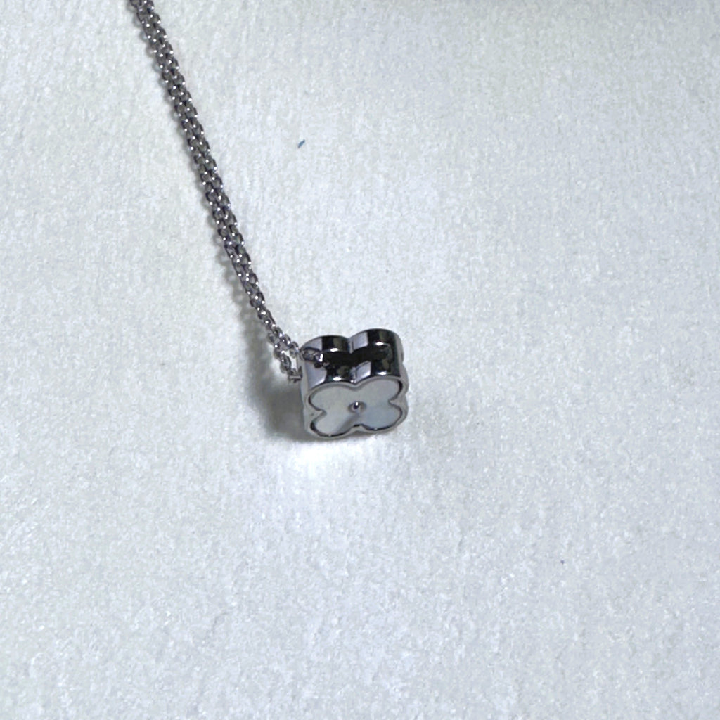 The clover turned to show its other face on the silver chain.
