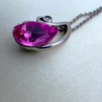 Close view of the pink pear cut stone and the small colourless stone at the tip of the swirl.