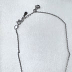 The cable chain laid out with the lobster clasp and extender chain.