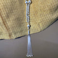 Sterling silver bead mala for Laddu Gopal with a snake chain tassel, on yellow fabric.