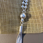The large front bead and the cap of the tassel on the silver bead mala.