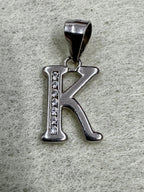 Close view of the sterling silver initial K pendant showing the channel of cubic zirconia and the tapered bail.