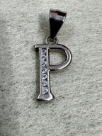 Close view of the sterling silver initial P pendant, showing the polished bowl and the line of cubic zirconia.