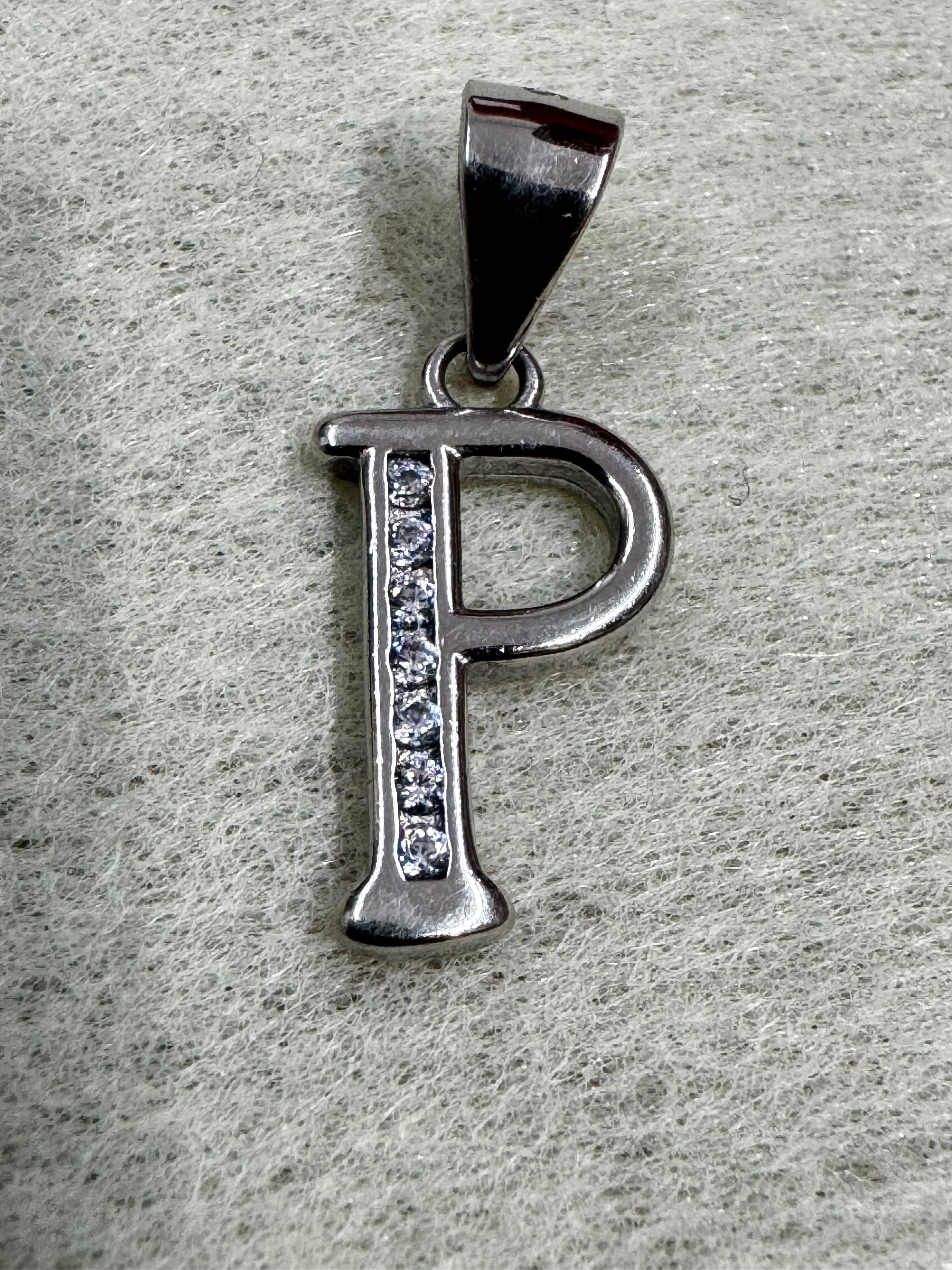 Close view of the sterling silver initial P pendant, showing the polished bowl and the line of cubic zirconia.