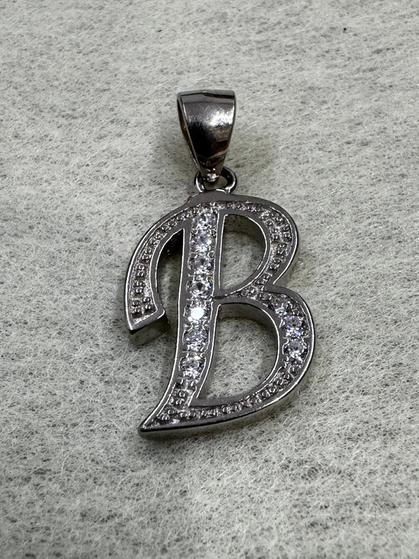 Sterling silver script initial B pendant with cubic zirconia pavé-set along its open strokes, on grey felt.
