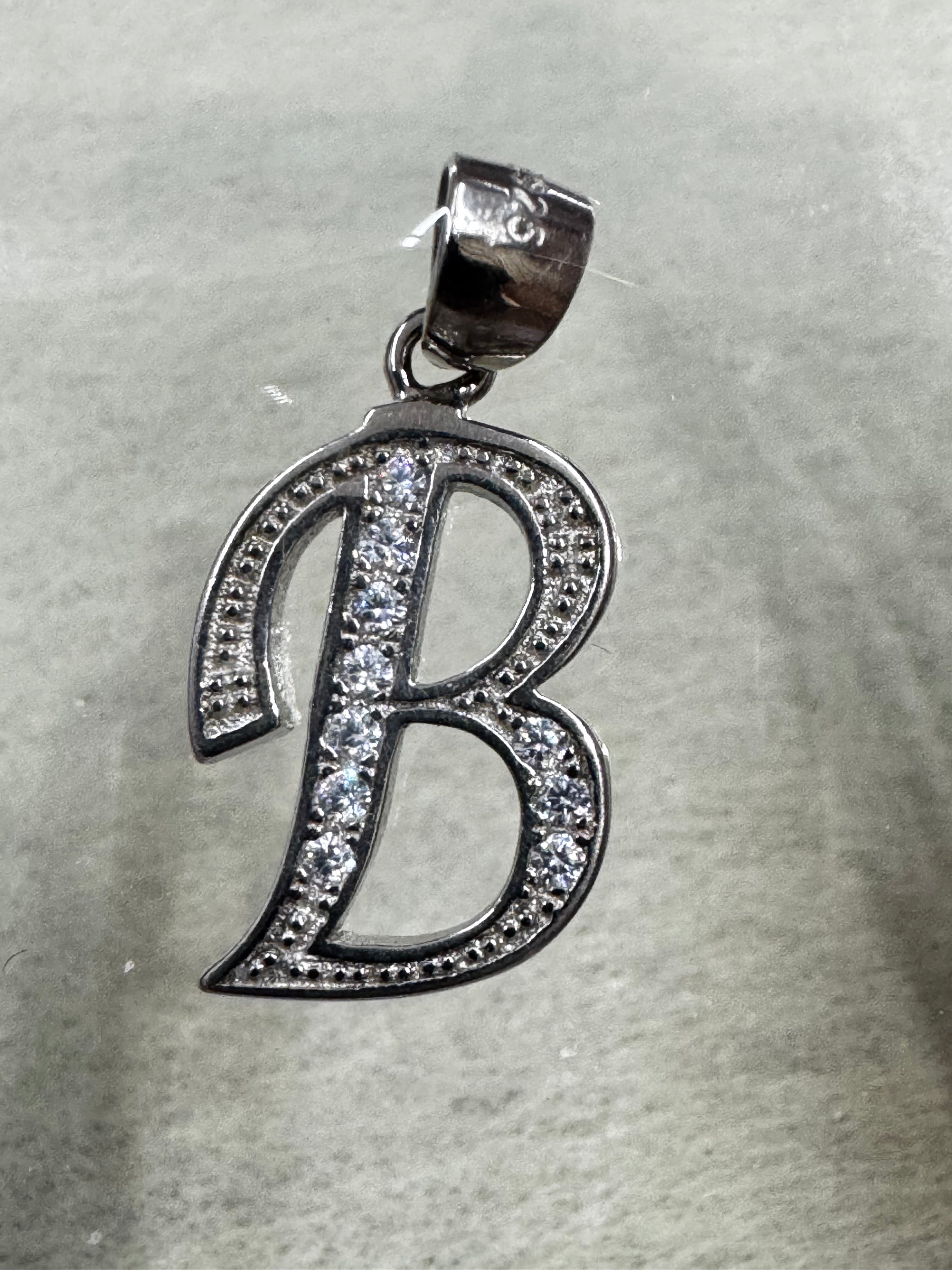 Close view of the sterling silver initial B pendant showing the row of larger cubic zirconia across the centre stroke.
