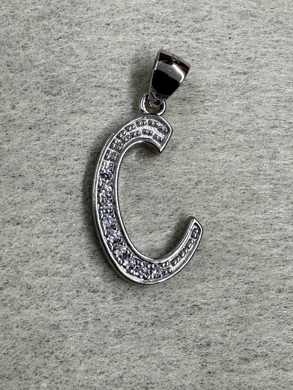 Close view of the sterling silver initial C pendant showing the beaded edging either side of the cubic zirconia.
