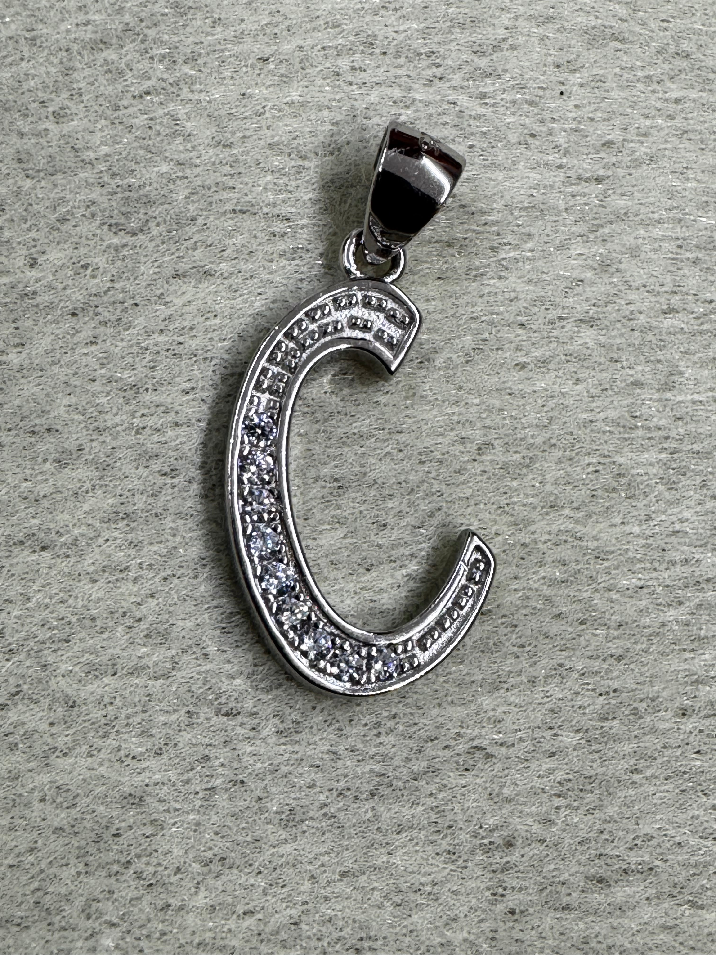 Close view of the sterling silver initial C pendant showing the beaded edging either side of the cubic zirconia.