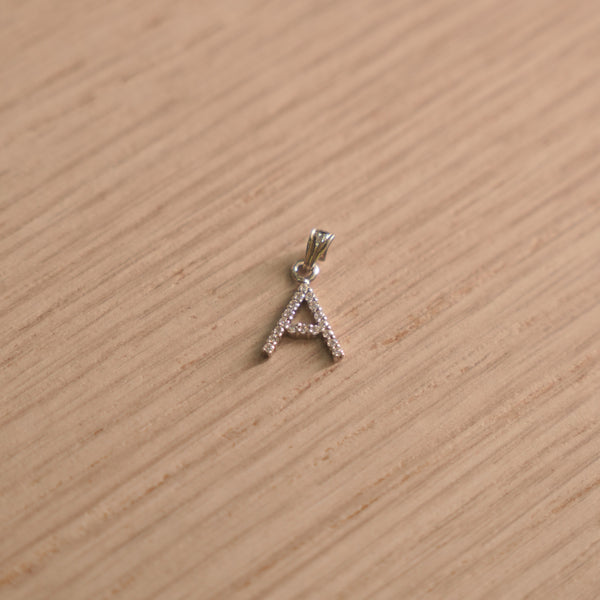 Sterling silver initial A pendant pave set with American Diamond, shown with its bail on a plain background.